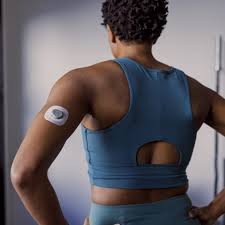 Athletic woman wearing CGM sensor on upper arm